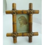 A BOUND BAMBOO EASEL FORM PHOTOGRAPH FRAME, displays an image 14cm x 9cm
