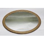AN EARLY 19TH CENTURY OVAL BEVEL PLATE WALL MIRROR, in refinished gilt gesso frame, 86cm tall (
