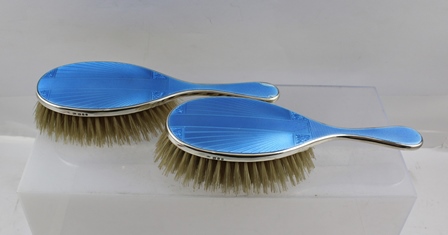 ** CO. A PAIR OF SILVER BACKED BLUE ENAMEL AND ENGINE TURNED LADY'S HAIR BRUSHES with geometric star
