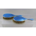 ** CO. A PAIR OF SILVER BACKED BLUE ENAMEL AND ENGINE TURNED LADY'S HAIR BRUSHES with geometric star