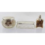 TWO CUT GLASS DRESSING TABLE JARS with silver covers, together with a plain SCENT BOTTLE with silver