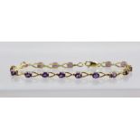 A GOLD COLOURED METAL BRACELET set sixteen oval amethysts in claw mounts