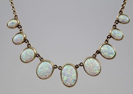 A 20TH CENTURY GOLD COLOURED METAL OPAL NECKLET, having nine oval cabochon stones, each in rub - Image 2 of 2