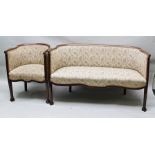 AN EDWARDIAN MAHOGANY SHOW WOOD FRAMED TWO SEATER SETTEE raised on cross frame feet, together with