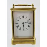 A FRENCH BRASS CASED CARRIAGE CLOCK, hinged handle, bevel plate glass panels, white enamel dial with