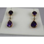 A PAIR OF CONTEMPORARY GOLD COLOURED METAL AMETHYST DROP EARRINGS, each having a circular stone in