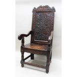 A PART 17TH CENTURY OAK WAINSCOT CHAIR, having high back with scroll crest, over chip carved