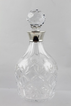 E**S**C** AN ENGLISH CUT LEAD CRYSTAL PORT WINE DECANTER with applied spun silver collar, Birmingham