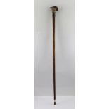 A WALKING STICK WITH A CARVED WOOD PARROT HEAD HANDLE, remains of original paint, inset glass