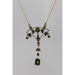 AN EDWARDIAN STYLE GOLD COLOURED METAL PERIDOT AND DIAMOND SET PENDANT, on chain, in the Art Nouveau