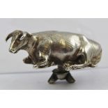 A 19TH CENTURY GEORGIAN SILVER FINIAL IN THE FORM OF A RECLINING COW, possibly off the lid of a