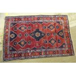 AN AFSHAR HAND-WOVEN WOOLLEN FLOOR RUG, having geometric patterned central field flanked by