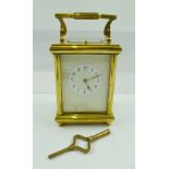 A LATE 19TH CENTURY BRASS CASED CARRIAGE CLOCK with inset bevelled glass panels, hinged handle,