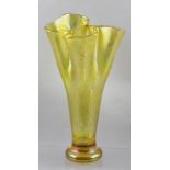 A LOETZ TYPE IRIDESCENT CITRINE GLASS VASE of trumpet form with pinched rim, on heavy circular base,