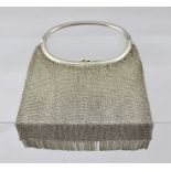 A SILVER CHAIN MAIL EVENING BAG, having oval combined handle and clasp, with tassel decoration,