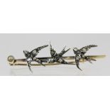 A VICTORIAN BAR BROOCH set with three Swallows in flight, having rose cut diamonds mounted in