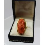 AN 18CT GOLD RING, inset with a carved coral cameo of a full bearded classical bust, profile size of