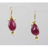 A PAIR OF VICTORIAN STYLE POLISHED RUBY AND SEED PEARL EARRINGS on wire fittings