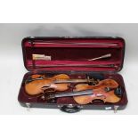 TWO FULL SIZE VIOLINS unlabelled, one with single piece back, housed in a double violin case with