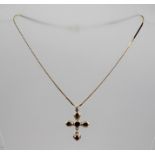 A 9CT GOLD AND GARNET SET CROSS and chain, having central heart shaped garnet with four pear