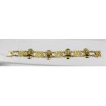 A HEAVY 18CT GOLD MASK HEAD AND DIAMOND SET BRACELET, the masks set with rubies and diamonds