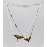 TWO ART NOUVEAU STYLE NECKLETS, one opalescent bead and pearl with winged mask pendant