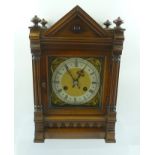 A MAHOGANY CASED MANTEL CLOCK, having architectural roof form top with turned finials, the dial with