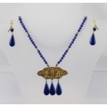 A BLUE FACETED GLASS NECKLACE and matching EARRINGS with Oriental figured medallion drop