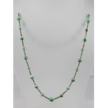 A PERIOD CUT STEEL AND NEPHRITE JADE BEAD NECKLACE with snap clasp, 66cm long