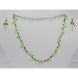 A SWAROVSKI STYLE GREEN CRYSTAL NECKLACE together with matching earrings with bow and wire fittings