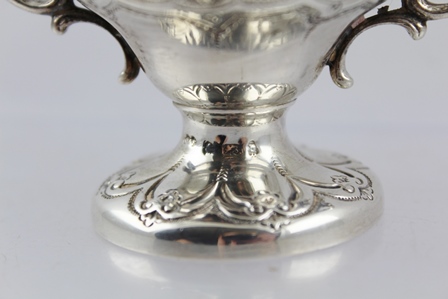 A LATE VICTORIAN WHITE METAL TABLE CIGAR LIGHTER of twin handled urn design with repousse - Image 3 of 3