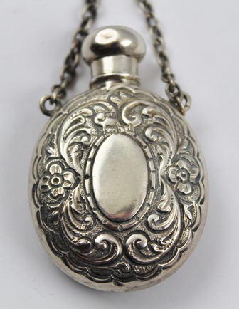 GEORGE UNITE A SILVER SCENT FLASK of oval form with screw cap and chain handle, embossed floral - Image 2 of 4