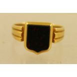 AN 18CT GOLD VICTORIAN BLOODSTONE SHIELD SHAPE RING, having ribbed shoulders on plain shank, size Y