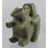 AN INUIT SOFT STONE CARVING OF AN ESKIMO grappling with a bear (man has inset carved bone face) 13cm