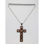 A "LISA CARNEY DESIGN" SILVER CROSS, set with seven cut stones, on a silver chain, cross 7.5cm high