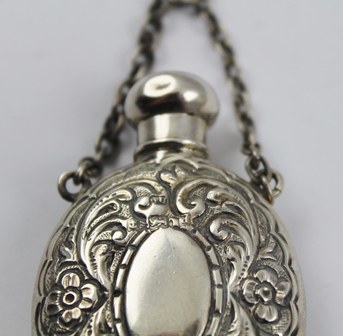 GEORGE UNITE A SILVER SCENT FLASK of oval form with screw cap and chain handle, embossed floral - Image 3 of 4