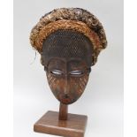 A CARVED WOOD AFRICAN TRIBAL FACE MASK with remains of original pigment, having woven full head of