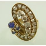 A 1970's 9CT GOLD DIAMOND AND SAPPHIRE DESIGNER FINGER RING, set with three sapphires, twenty old