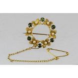 A VICTORIAN GOLD OLIVINE AND SEED PEARL BROOCH, fashioned as a circular garland with floral rosettes