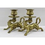 A PAIR OF 19TH CENTURY CAST BRASS CHAMBERSTICKS each cast as a mythical creature, his tail curled to