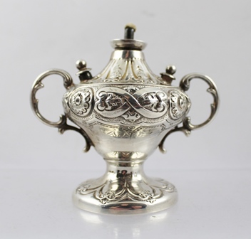 A LATE VICTORIAN WHITE METAL TABLE CIGAR LIGHTER of twin handled urn design with repousse
