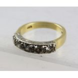 AN 18CT GOLD RING set with five diamonds, the shank engraved with scrolls