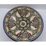 A CONTINENTAL GLAZED SHALLOW TERRACOTTA BOWL, having hand painted decorative design in blue, red,