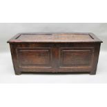 A LATE 17TH CENTURY OAK COFFER having twin panelled lid over a box base, raised on stile end