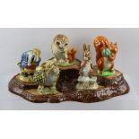 A BESWICK EARTHENWARE TREE STUMP BASE WITH FIVE BEATRIX POTTER FIGURES, to include "Fierce Bad