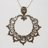 AN ANTIQUE SILVER MOUNTED DIAMOND SET PENDANT, having contemporary style horse shoe frame set with