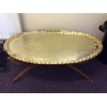 Two brass topped oval coffee tables on wooden frames.