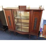 An early 20th Century mahogany china display cabinet with glazed bow from centre flanked with