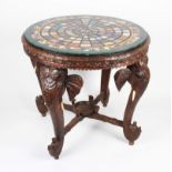 A 20th Century carved oak table with four elephant head design legs with bone tusks, with a marble