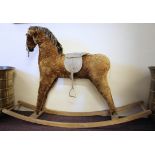 A mid 20th Century rocking horse with plush finish body with saddle on wooden rockers.